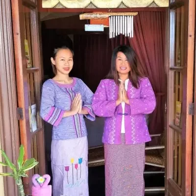 two women in purple outfits standing in a doorway